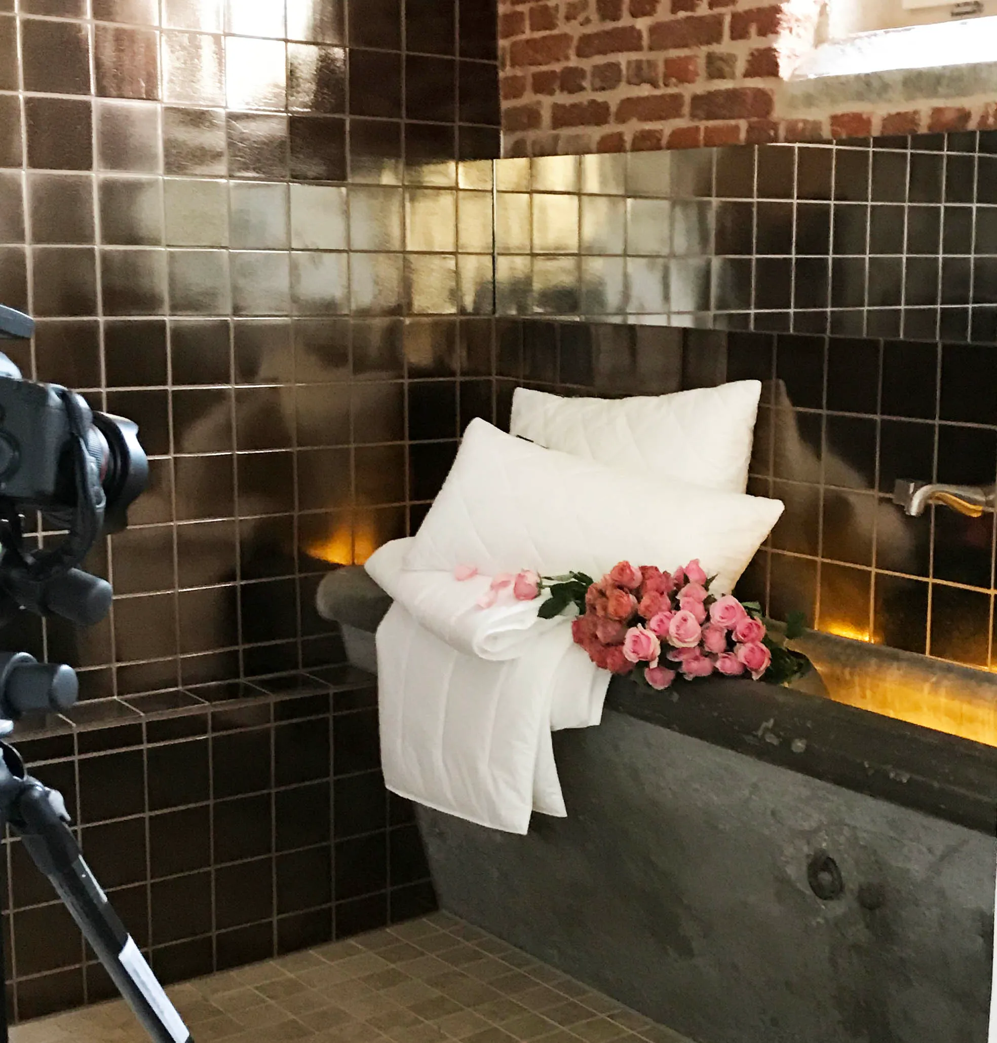 Dunkel gefliestes Bad mit Rosen auf der Wanne